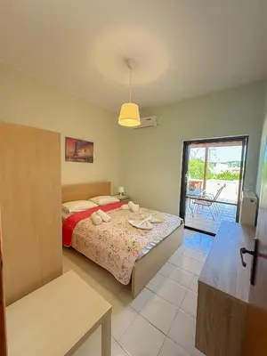a bedroom with a bed and a view of a patio at Villa Marianna Lygides in Ayiá