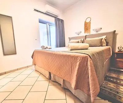 a bedroom with a bed and a large window at Infinity Wellness Boutique Hotel in Afráta