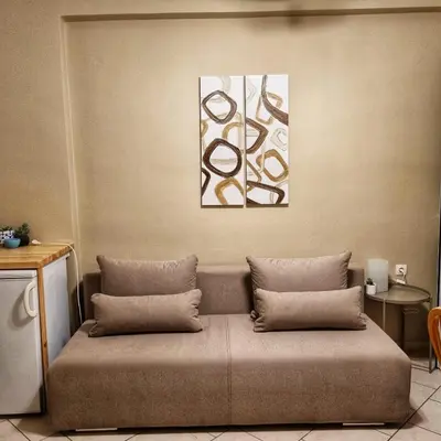 a couch with two pillows in a room at Infinity Wellness Boutique Hotel in Afráta