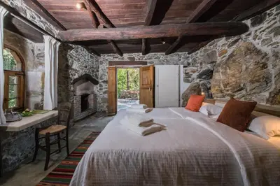 a bedroom with a large bed and a fireplace at Μilia Mountain retreat in Vlátos