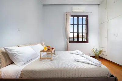 a white room with a bed and a window at Clio Townhouse in Chania Town