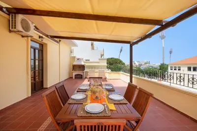 a wooden table on a patio with chairs and a balcony at Clio Townhouse in Chania Town