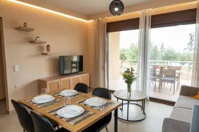 a dining room with a table and chairs and a television at Terra Blue Suites - Dimitra in Kalyves