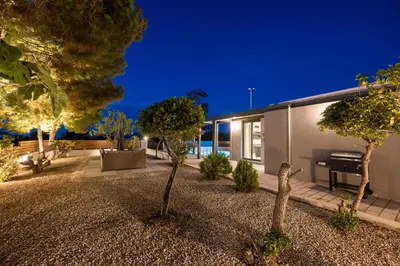 a house with a garden at night with a piano at Natura Hill Villa I Sea View in Kounoupidhianá