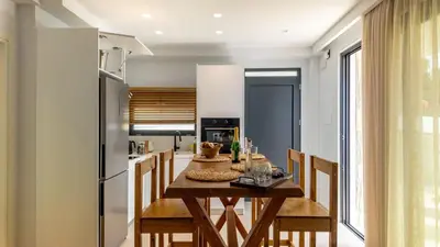 a kitchen and dining room with a wooden table and chairs at D PALM Premium Living - Kalathas, Chania in Chania Town