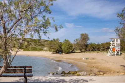 a bench sitting next to a beach with a lifeguard tower at Maria's House in Chania in Kounoupidhianá