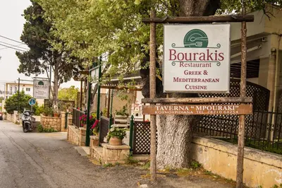 a sign for a restaurant on a street at Maria's House in Chania in Kounoupidhianá