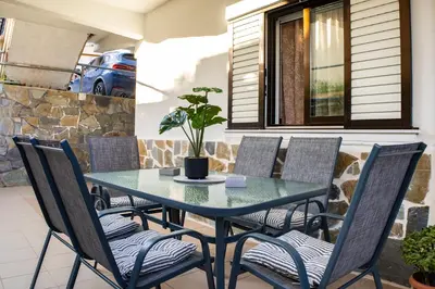 a table and chairs with a potted plant on a patio at Maria's House in Chania in Kounoupidhianá