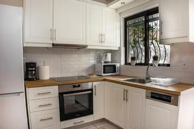 a kitchen with white cabinets and a sink and a microwave at Maria's House in Chania in Kounoupidhianá