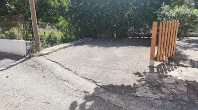 a wooden fence on the side of a driveway at liofito village house in Pemónia