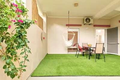 a living room with green grass and a table and chairs at Cretan Fun in Stalos