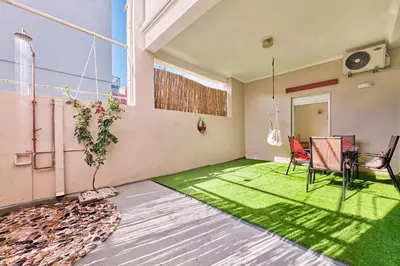a room with a table and chairs and a green rug at Cretan Fun in Stalos
