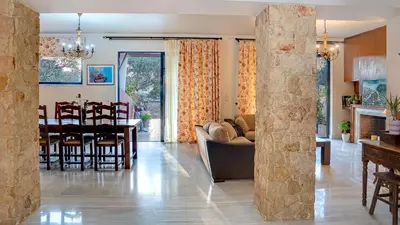 a living room and dining room with a dining table at Lithos Serenity in Argoulidhés