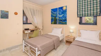 a bedroom with two beds and a desk at Lithos Serenity in Argoulidhés