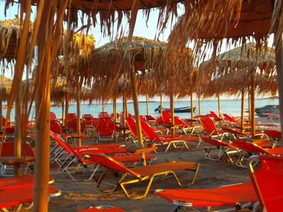 a bunch of lawn chairs and umbrellas on a beach at Pool Villa Kamara Crete - Chania in Chania Town
