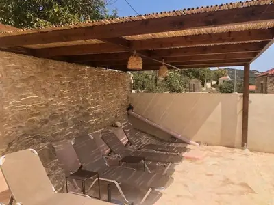a group of chairs sitting next to a stone wall at Pool Villa Kamara Crete - Chania in Chania Town