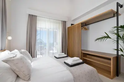 a bedroom with a large white bed and a window at Villa Athena - Crete Pickleball Paradise in Vamos