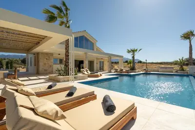 a villa with a swimming pool with lounge chairs at Villa Athena - Crete Pickleball Paradise in Vamos
