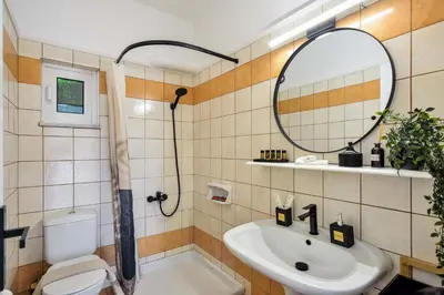 a bathroom with a sink and a toilet and a mirror at La Fleur in Chania Town