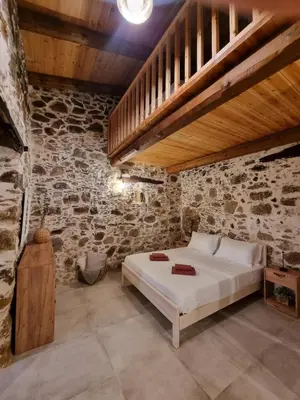 a bedroom with a bed in a stone wall at Mesavlia Traditional Stone House in Mesávlia