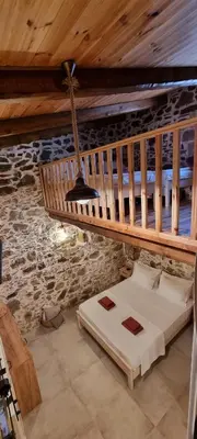 a bed in a room with a wooden ceiling at Mesavlia Traditional Stone House in Mesávlia