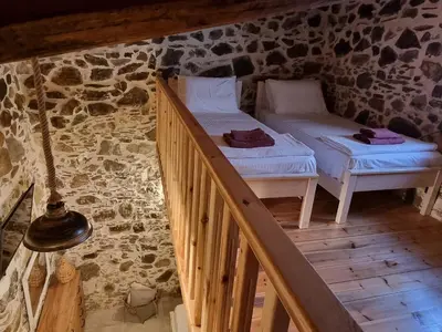 a room with two beds in a stone wall at Mesavlia Traditional Stone House in Mesávlia