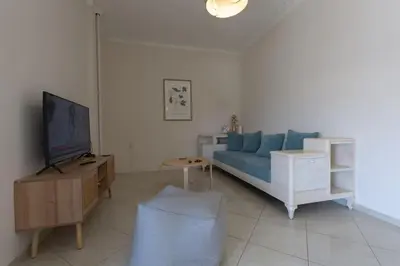 a living room with a blue couch and a tv at Κidonias home in Chania Town
