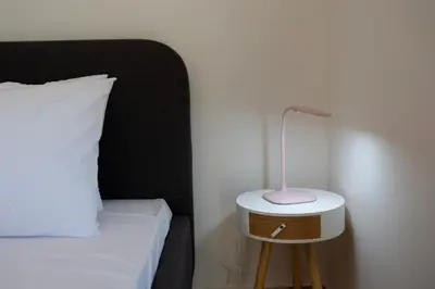 a bed with a table with a lamp on it at Κidonias home in Chania Town