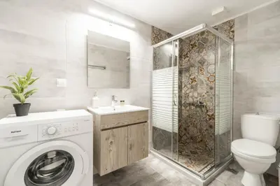 a bathroom with a washing machine and a shower at Avra Sfakia Apartments in Khóra Sfakíon