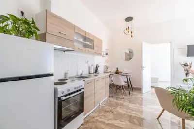 a kitchen with white appliances and a dining room with a table at Avra Sfakia Apartments in Khóra Sfakíon