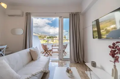 a living room with a white couch and a table at Avra Sfakia Apartments in Khóra Sfakíon