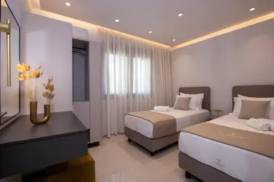 a hotel room with two beds and a television at Tersus Luxury Villa in Kalyves