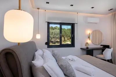 a bedroom with a large bed with a window at Tersus Luxury Villa in Kalyves
