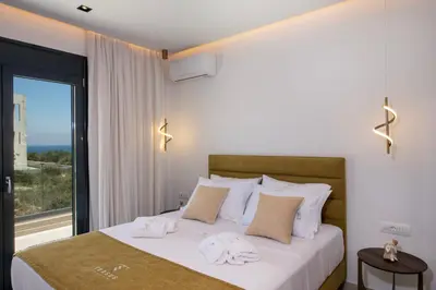 a bedroom with a bed with towels on it at Tersus Luxury Villa in Kalyves