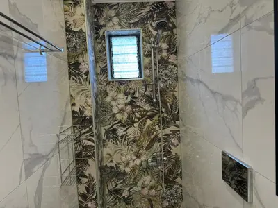 a bathroom with a shower with a window on the wall at Sofia Rooms in Palaiochóra