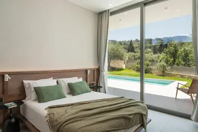 a bedroom with a bed and a view of a pool at VILLA PETRA PHILIPPOS heated pool optional in Khámbatha