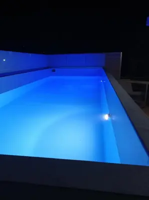 a large swimming pool with blue illumination at City Apartment with heated rooftop Pool in Chania Town