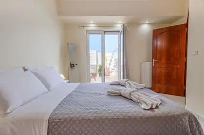 a bedroom with a bed with towels on it at City Apartment with heated rooftop Pool in Chania Town