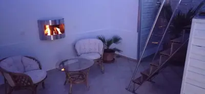 a room with chairs and a table and a light at City Apartment with heated rooftop Pool in Chania Town