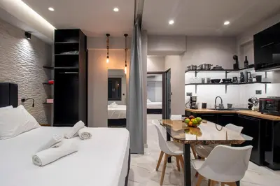 a bedroom with a white bed and a table and chairs at Melina's - Urban Luxury 2-Bath Apt with 2 Balconies - Heart of Chania in Chania Town