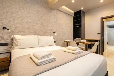 a bedroom with a white bed with towels on it at Melina's - Urban Luxury 2-Bath Apt with 2 Balconies - Heart of Chania in Chania Town