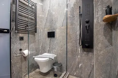 a bathroom with a toilet and a glass shower at Melina's - Urban Luxury 2-Bath Apt with 2 Balconies - Heart of Chania in Chania Town