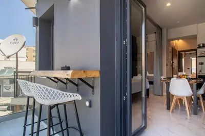 a room with a counter and chairs and a window at Melina's - Urban Luxury 2-Bath Apt with 2 Balconies - Heart of Chania in Chania Town