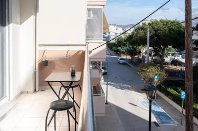 a balcony with a table and a view of a street at Niman Beachside Apartments in Chania Town