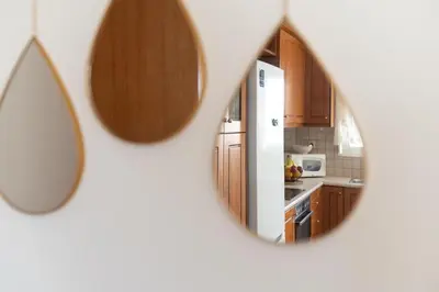 a kitchen with wooden cabinets and a kitchen mirror at Niman Beachside Apartments in Chania Town