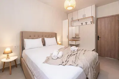 a bedroom with a bed with two towels on it at Niman Beachside Apartments in Chania Town