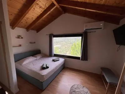a bedroom with a bed and a large window at Vrysses Lodge Michael Stelianos in Vryses