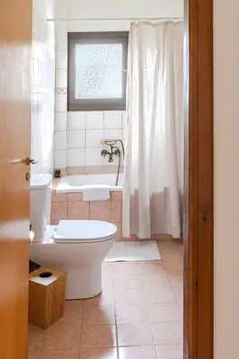 a bathroom with a tub and a toilet and a bath tub at The Yard Residence in Gavalochori