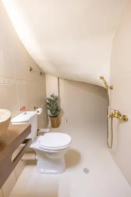 a white bathroom with a toilet and a sink at The Yard Residence in Gavalochori