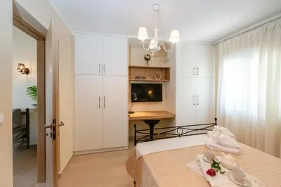 a bedroom with a bed with white cabinets and a desk at Villa Noelia in Rogdhiá